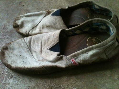 sepatu yang babak belur karena lumpur.